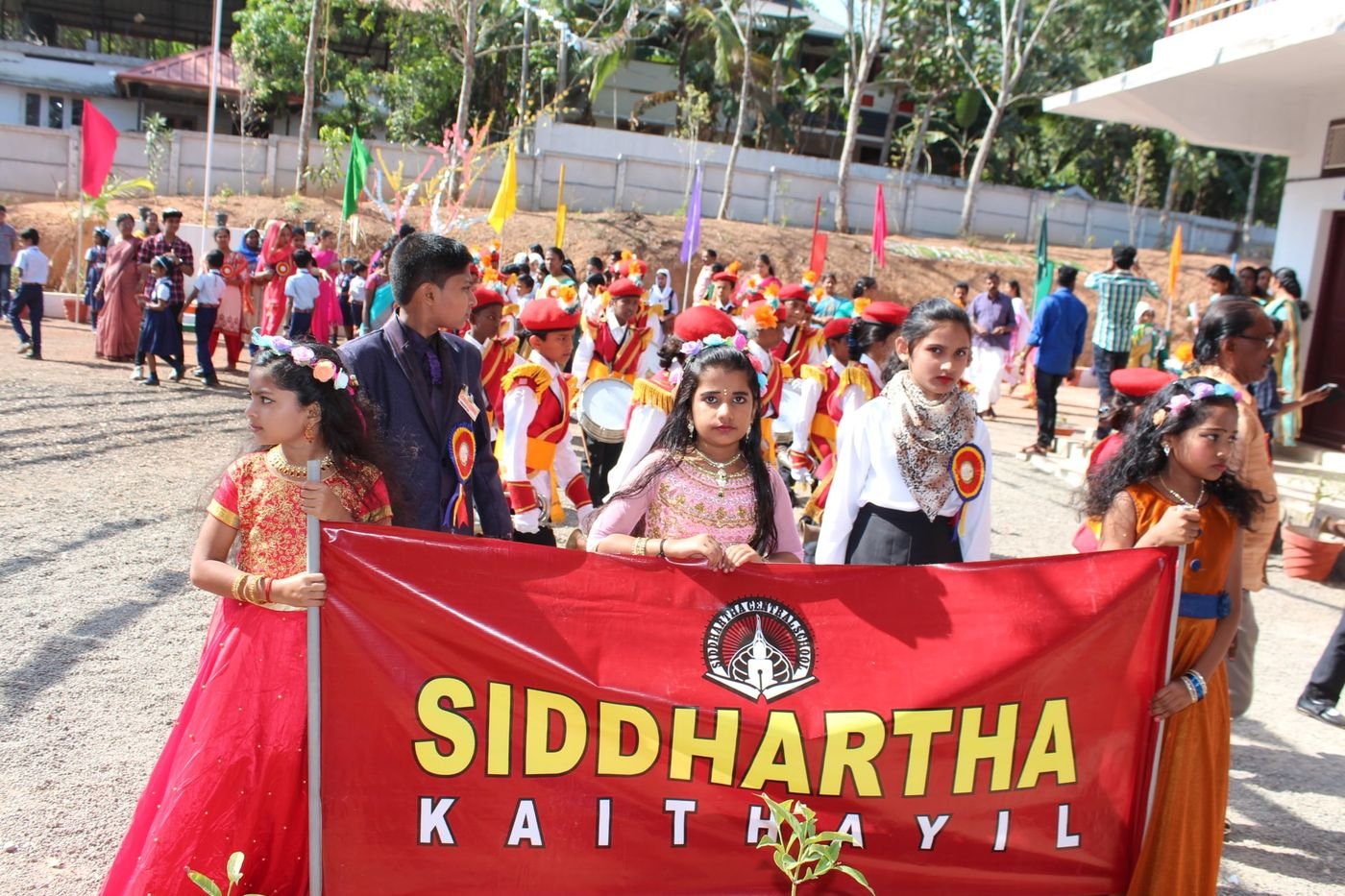 Students leading a school procession with the Siddhartha banner